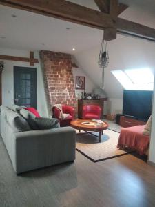 ein Wohnzimmer mit einem Sofa und einem Tisch in der Unterkunft Suite familiale Mamito et Papito in Notre-Dame-du-Bec