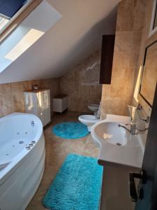 a bathroom with two sinks and a tub and two toilets at Villa Florencia in Bardejov