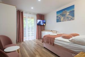 Un dormitorio con una cama y una ventana grande. en Willa Rosa-apartamenty z prywatną sauną, en Szklarska Poręba
