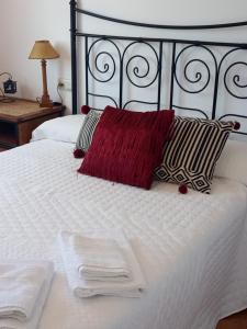 a white bed with white sheets and red pillows at Cerca de la playa, con bodega, terraza y jardin Camino Portugués in A Guarda +26 photos