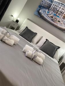 una camera da letto con un letto bianco e asciugamani di B&B Palermo Pirri a Palermo