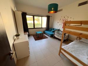 Habitación con litera y sofá en Apartment at Samarah Dead Sea Resort, en Sowayma