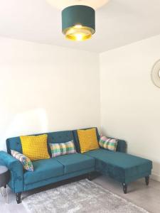 ein blaues Sofa im Wohnzimmer mit gelben Kissen in der Unterkunft The Reginald in Leeds