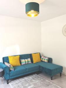 a blue couch in a living room with yellow pillows at The Reginald in Leeds