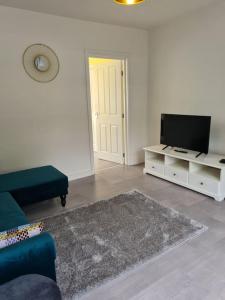 ein Wohnzimmer mit einem Sofa und einem TV in der Unterkunft The Reginald in Leeds