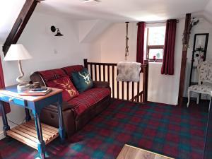 uma sala de estar com um sofá e uma mesa em Willow's Cottage em Edwinstowe