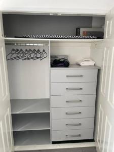 a white closet with white drawers at Grays Serviced Apartment in Stifford
