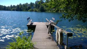 a wooden dock on a lake with benches on it at Kotoisa Parkkipaikallinen Kaksio Kangasalan Keskustassa in Kangasala
