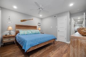 1 dormitorio con 1 cama y ventilador de techo en Sunrise Villas 208- Pool & Boardwalk to the beach, en Port Aransas