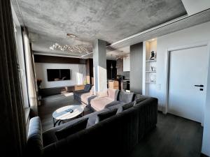 a living room with a couch and a table at Jonas Hill SkyView Apartment in Klaipėda +17 photos