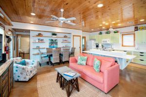 a living room with a pink couch and a kitchen at The RITZ Tarpon- VW 83 in Port Aransas