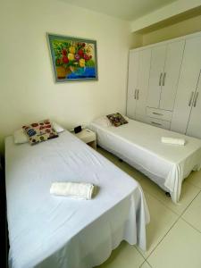 um quarto com duas camas e um quadro na parede em Aptos atrás da Passarela do Caranguejo em Aracaju