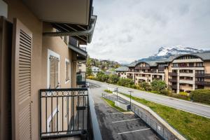 a balcony with a view of a street and mountains at A magnificent apartment in the beautiful French mountains in Saint-Gervais-les-Bains