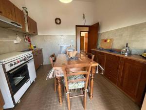 eine Küche mit einem Tisch mit Stühlen und einem Herd in der Unterkunft Appartamento “Rosy” in Stia