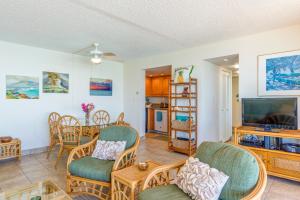 un soggiorno con TV a schermo piatto e sedie di Nohonani 203 a Kahana