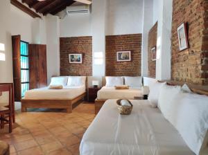 HOTEL NIETO MOMPOX, ubicado en el corazón del centro histórico, frente al rio magdalena en zona de malecón客房内的一张或多张床位