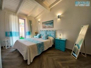ein Schlafzimmer mit einem Bett, einer blauen Kommode und einem Spiegel in der Unterkunft Villa al mare - I CORALLI in Valledoria