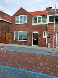 um edifício de tijolos vermelhos com janelas numa rua em House with garden in the center close to the sea and Amsterdam em Beverwijk