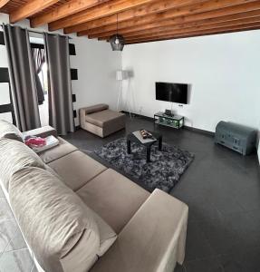 a living room with a couch and a flat screen tv at Silva House Refuge in Algarvia