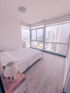 a bedroom with a bed and a view of a city at Luminous Excellence City Center - PH Quartier Atlapa in Panama City