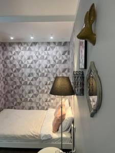 a bedroom with a bed with a lamp and a tiled wall at Warsaw Dream w sercu miasta - FREE PARKING - nowy most in Warsaw