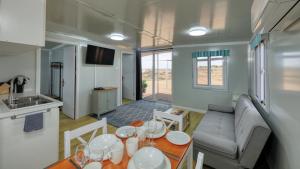 a kitchen and a living room with a table and a couch at White Cliffs Self Contained Cabin Accommodation in White Cliffs