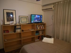 a bedroom with a book shelf with a television on it at Micuman Habitaciones en microcentro con baño privado in San Miguel de Tucumán