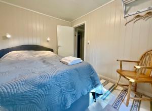 ein Schlafzimmer mit einem blauen Bett und einem Stuhl in der Unterkunft Cozy apartment Leknes Lofoten in Leknes