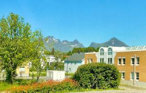un gruppo di edifici con montagne sullo sfondo di Cozy apartment Leknes Lofoten a Leknes