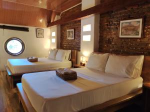 um quarto com duas camas num quarto em HOTEL NIETO MOMPOX, ubicado en el corazón del centro histórico, frente al rio magdalena en zona de malecón em Santa Cruz de Mompox