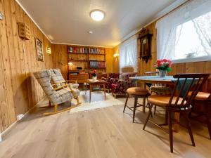 a living room with wooden walls and a table and chairs at Cozy apartment Leknes Lofoten in Leknes