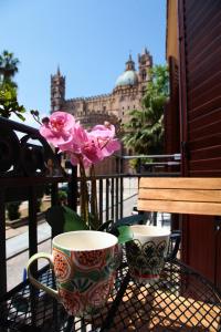 une table avec deux tasses et une fleur sur un balcon dans l'établissement Alle Absidi della Cattedrale, à Palerme