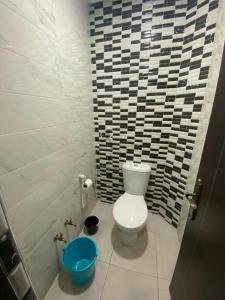 uma casa de banho com WC e um balde azul em أكادير ايت ملول em Ait Melloul