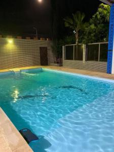 a large blue swimming pool at night at أكادير ايت ملول in Ait Melloul