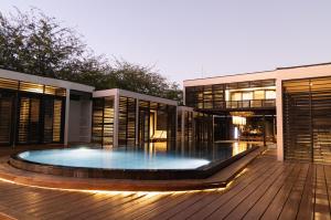 una casa con piscina en una terraza de madera en 99 Surf Lodge en El Limón