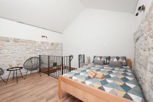 a bedroom with a bed and a stone wall at Holiday Stone House - Fumarea in Rtina