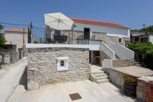 a stone house with an umbrella on top of it at Holiday Stone House - Fumarea in Rtina