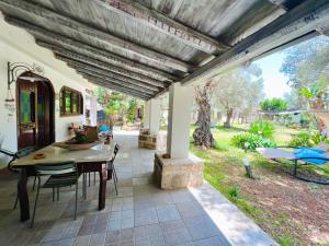 una sala da pranzo con tavolo e sedie su un patio di Villa Esmeralda a Carini