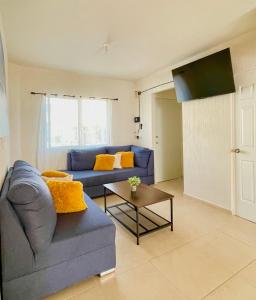 a living room with a blue couch and a table at Casa familiar 3 habitaciones Playa del Carmen in Playa del Carmen