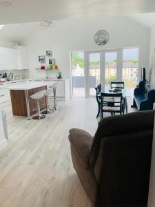 a living room and kitchen with a couch and a table at Station House in Ballina