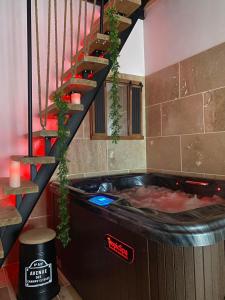 eine Whirlpool-Badewanne in einem Zimmer mit einer Treppe in der Unterkunft Maison avec JACUZZI Privatif, L'Antre 2, WIFI,TV,CLIM in Bessan
