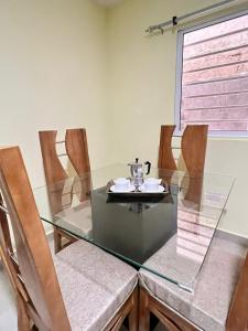 una mesa de cristal con sillas y un hervidor de agua. en Hotel La playa, en Santa Cruz de Barahona