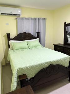 ein Schlafzimmer mit einem großen Bett mit grüner Bettwäsche in der Unterkunft Hotel La playa in Santa Cruz de Barahona