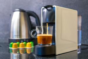 eine Kaffeemaschine auf einer Theke mit einer Tasse Kaffee in der Unterkunft Deluxe Apartments in Palermo in Buenos Aires