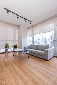 a white living room with a couch and a table at Impressive Family City View Apt B - PH Quartier Marbella in Panama City