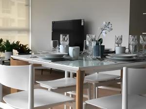 a dining room table with white chairs and a white table and chairsktop at Impressive Family City View Apt B - PH Quartier Marbella in Panama City