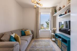 uma sala de estar com um sofá e uma televisão em Villa KaTess with heated pool em Split