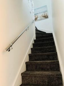 a stairway with a picture of the beach on the wall at Station House in Ballina