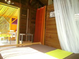 a bedroom with a bed and a window and a table at Vacances Bien Etre Guadeloupe in Bouillante