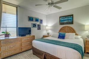 a bedroom with a bed and a flat screen tv at Paki Maui 403 in Kahana +26 photos